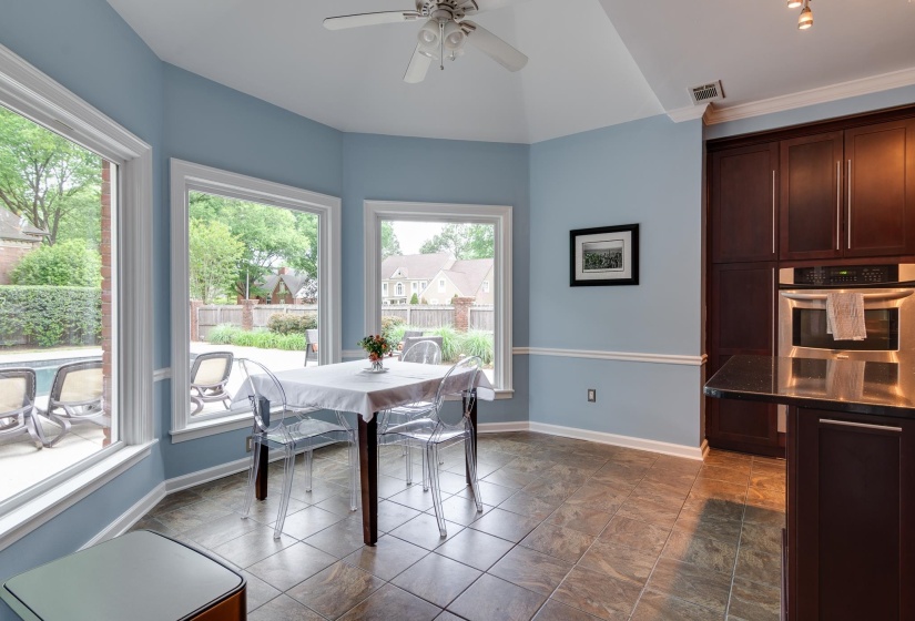 Breakfast nook with multiple windows, vaulted ceiling, and ceiling fan