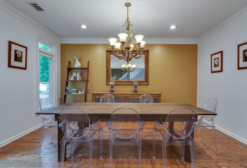 Dining area featuring wood-finish flooring, recessed lighting, and a prominent chandelier