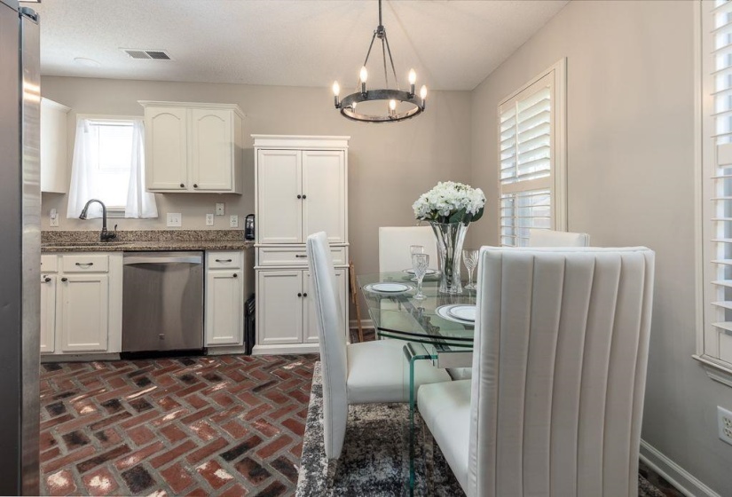 Kitchen and dining area featuring herringbone brick flooring