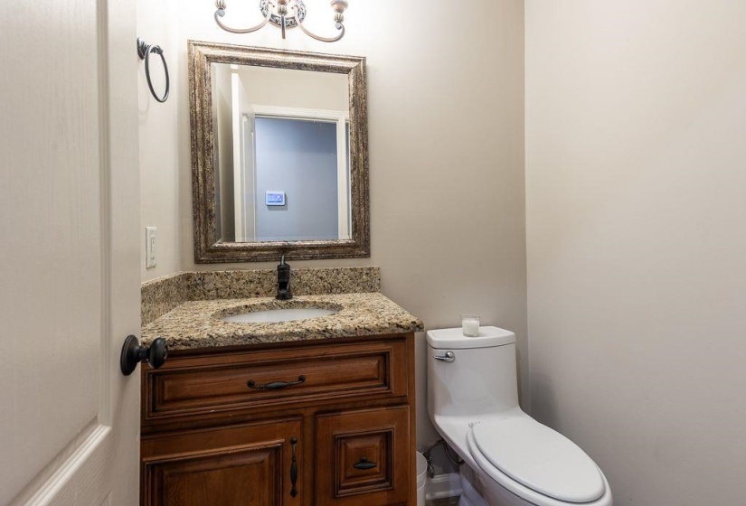 Bathroom featuring a wood vanity with a granite countertop, undermount sink, and oil-rubbed bronze faucet