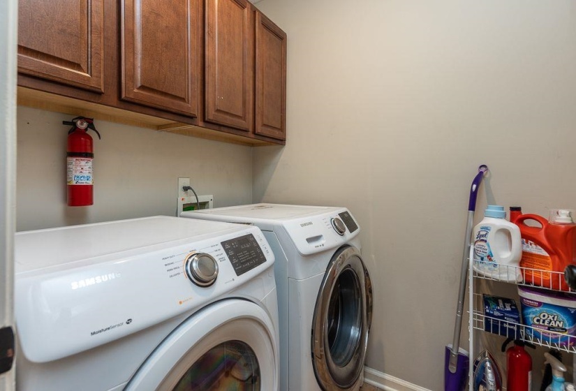 Dedicated laundry area featuring overhead cabinetry