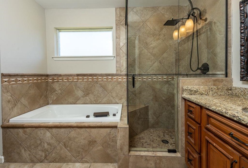 Tiled soaking tub and walk-in shower with glass enclosure