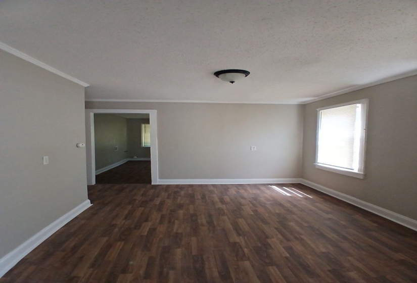 Spacious room with wood-finish flooring and a neutral wall palette