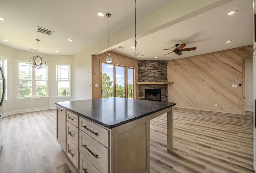 Kitchen island with dark countertop, integrated cabinetry, and pendant lighting