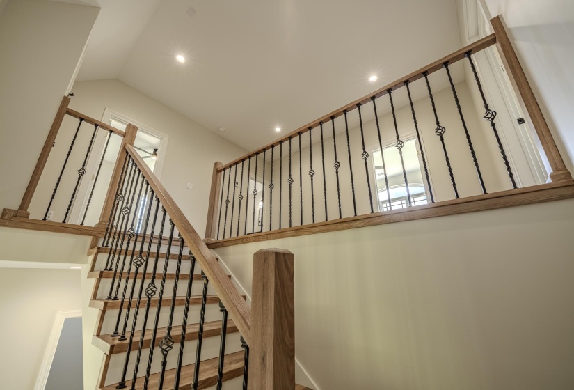 Wood-finish staircase with wrought iron balusters and natural wood handrails