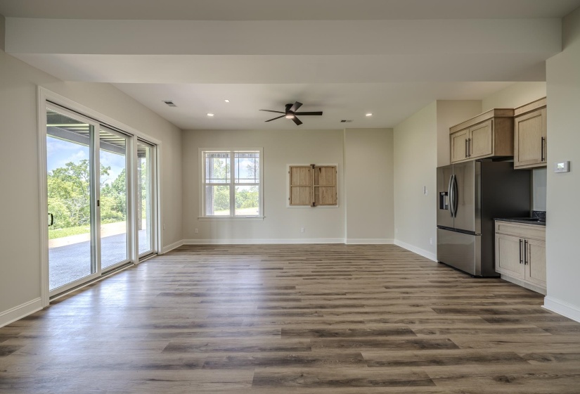 Spacious open-concept room featuring wood-finish flooring, recessed lighting, and a ceiling fan