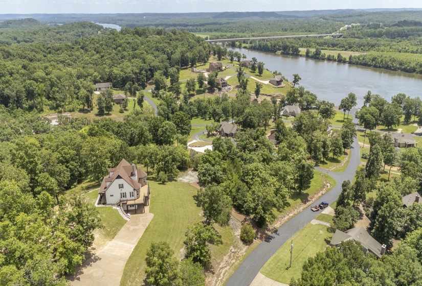 Residential property featuring a paved driveway, a manicured lawn, and a multi-level deck