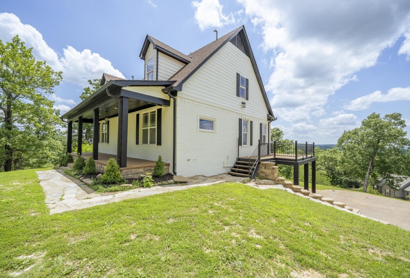 White siding exterior with a dark trim and a prominent covered porch