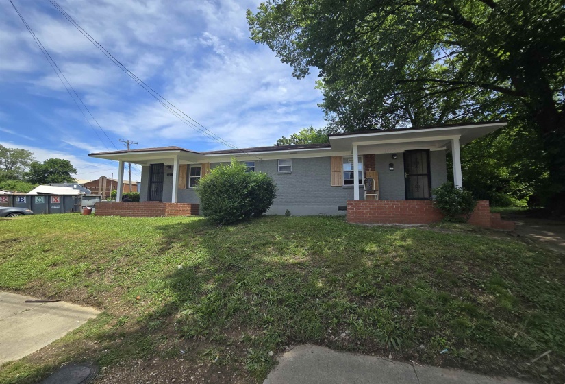 Duplex property featuring a gray painted exterior with white trim, brick porch foundations, and porch overhangs supported by white columns