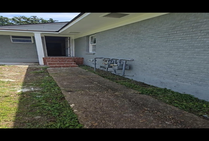 Light gray painted brick exterior with white trim and a covered entrance