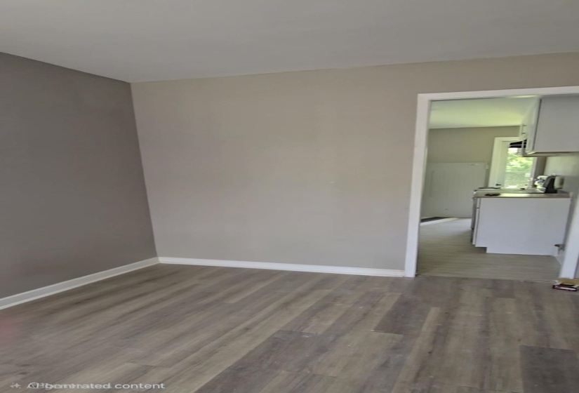 Interior space featuring wood-finish flooring, light neutral wall paint, and white baseboards