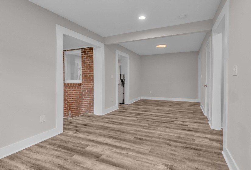 Spacious room featuring wood-finish flooring, light gray walls, white trim, and recessed lighting