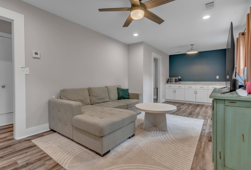 Spacious living area featuring wood-finish flooring, recessed lighting, and a ceiling fan