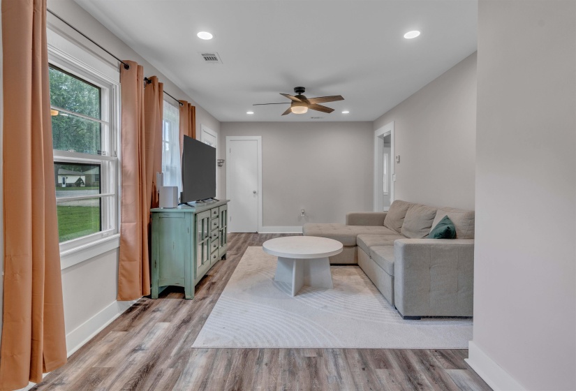 Living area featuring wood-finish flooring, recessed lighting, and a ceiling fan