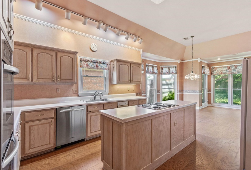 KITCHEN (32x12) – Impressive vaulted kitchen designed for both everyday living and entertaining, featuring a center island with    JennAir electric cooktop, KitchenAid double ovens, dishwasher, trash compactor, pantry, and abundant cabinet/counter space.