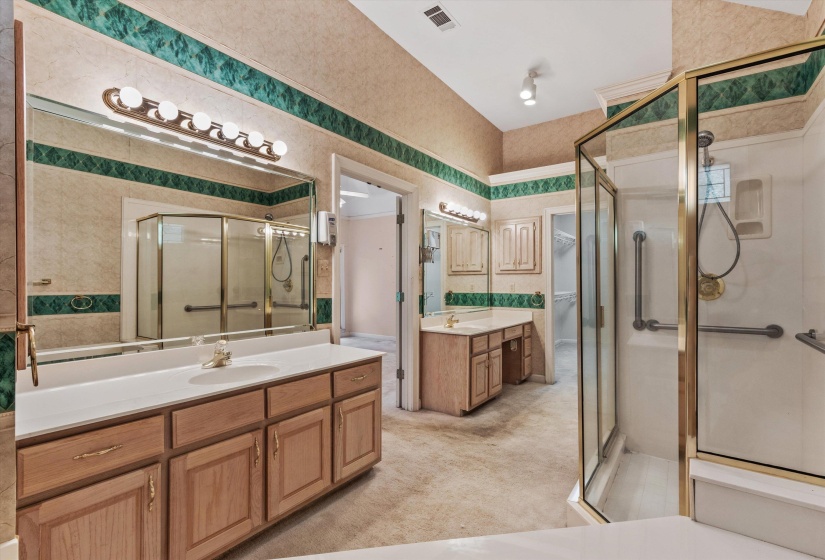 PRIMARY BATH – Spacious bath featuring dual vanities, whirlpool tub, separate walk-in shower, walk-in closet, private water closet, and ample room for daily comfort. Virtually staged photo.