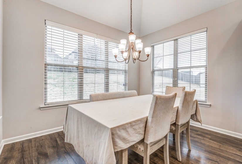 Dining space featuring suspended lighting and dark wood-type flooring