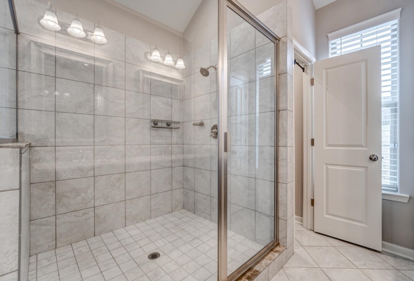 Bathroom with a stall shower and tile patterned flooring