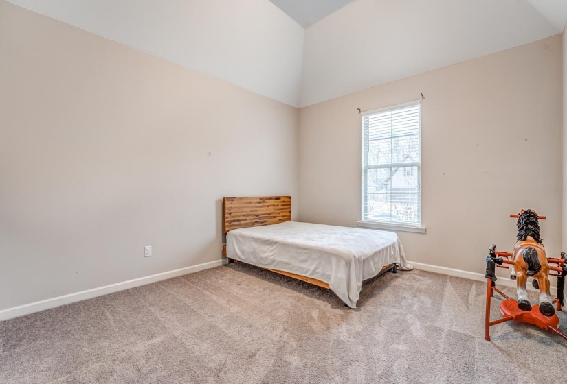 Bedroom featuring lofted ceiling and carpet floors