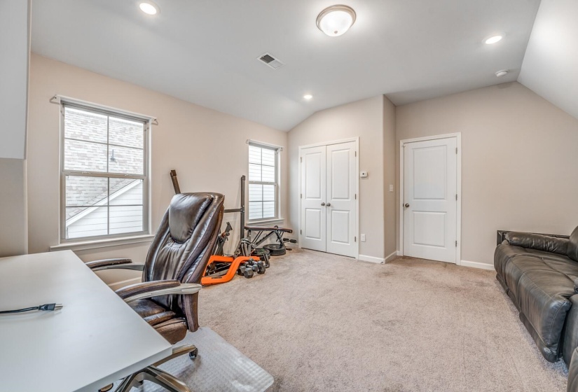 Office space featuring vaulted ceiling, light carpet, and recessed lighting