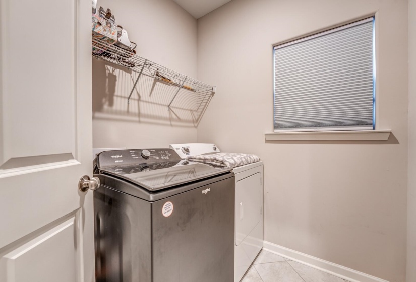 Laundry room featuring light tile patterned floors and washer and clothes dryer