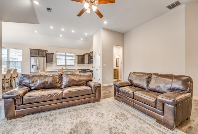 Living area featuring ceiling fan, light wood-style floors, recessed lighting, and lofted ceiling