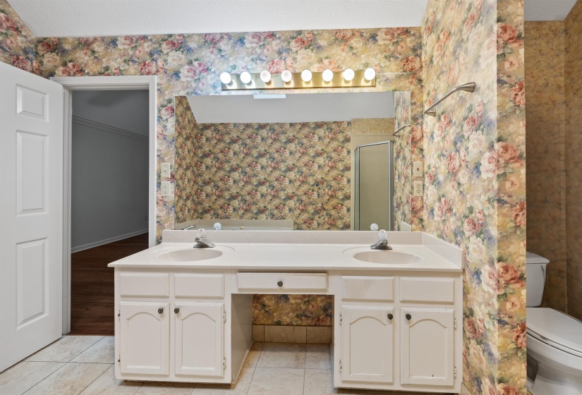 Vanity with dual integrated sinks, white cabinetry, and a central drawer