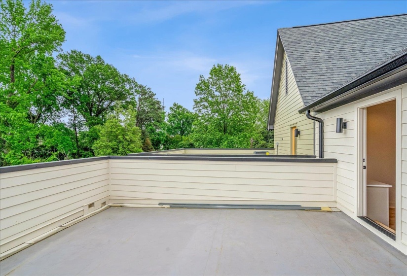 Expansive outdoor terrace featuring light-colored siding with dark trim, a durable gray surface, and direct access to interior spaces