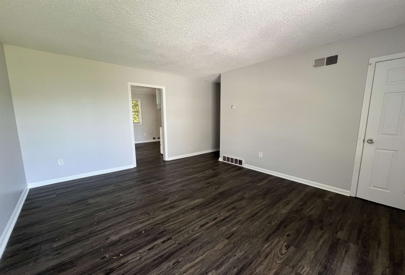 Wood-finish flooring with white baseboards and light gray walls
