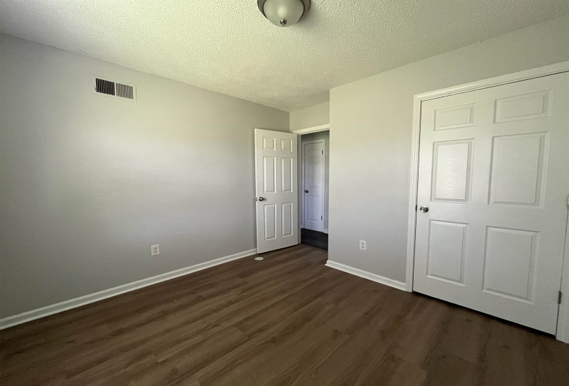 Room featuring wood-finish flooring, light gray wall paint, white trim, and a flush mount ceiling light