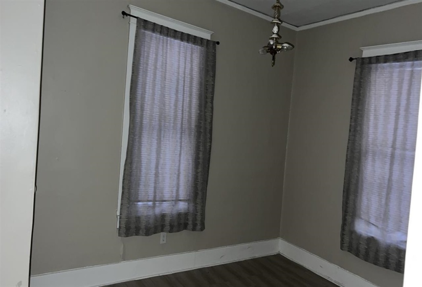 Room with light gray wall paint, white crown molding, and white baseboards