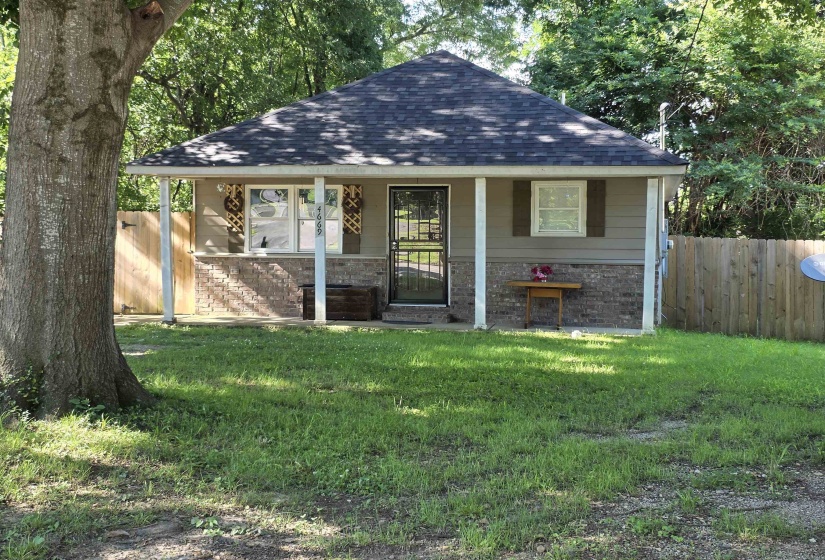 Inviting facade featuring a gabled roof, a covered porch with supporting columns, and a brick base