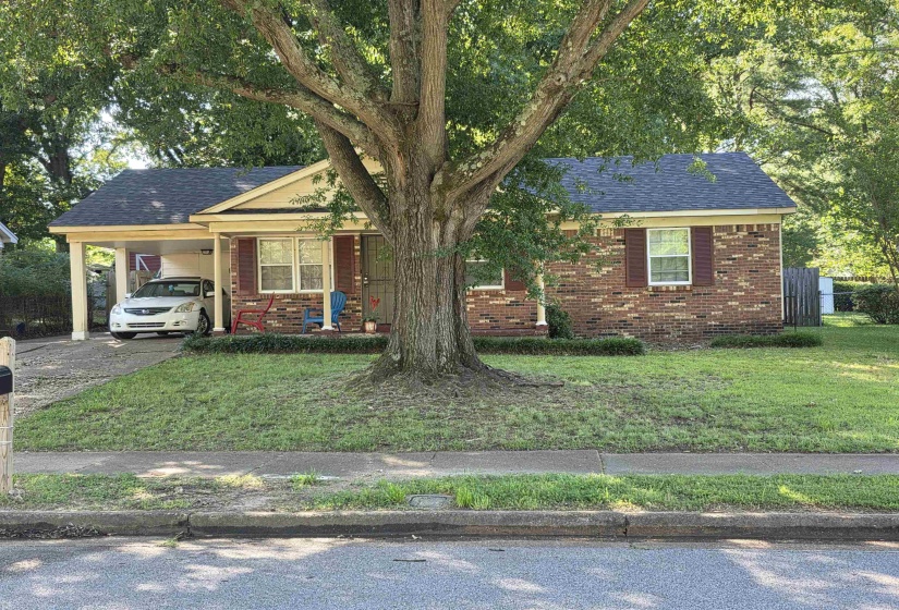 Brick exterior with contrasting dark shutters and a covered carport