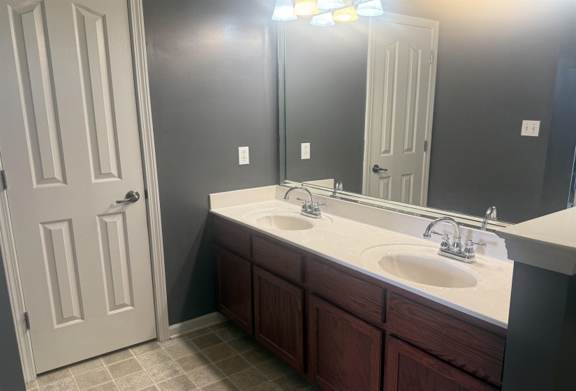 Double vanity featuring two integrated sinks, chrome faucets, and a light-toned countertop