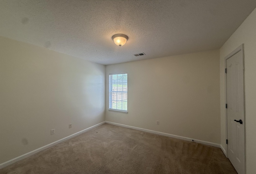 Carpeted interior room with neutral-toned walls
