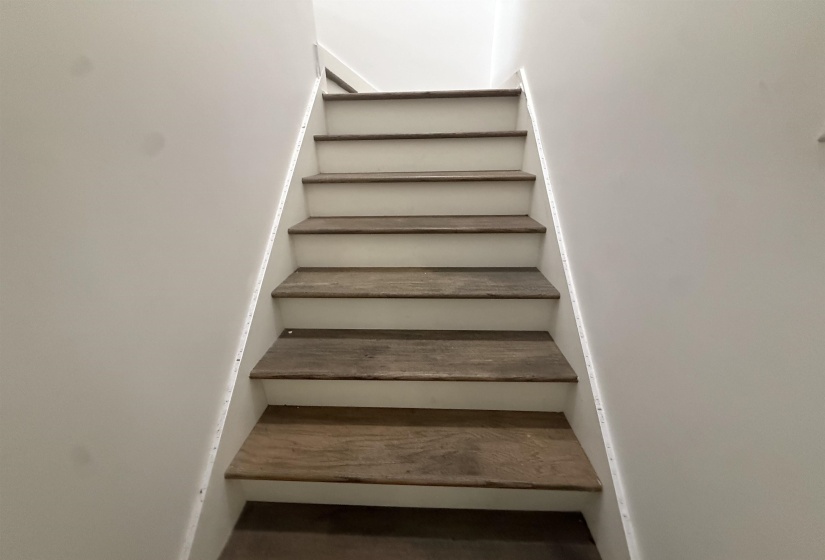 Staircase featuring wood-finish treads and white risers
