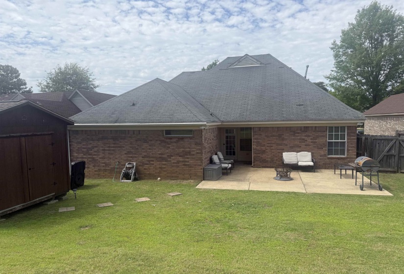 Brick exterior featuring a gabled roofline and rear patio