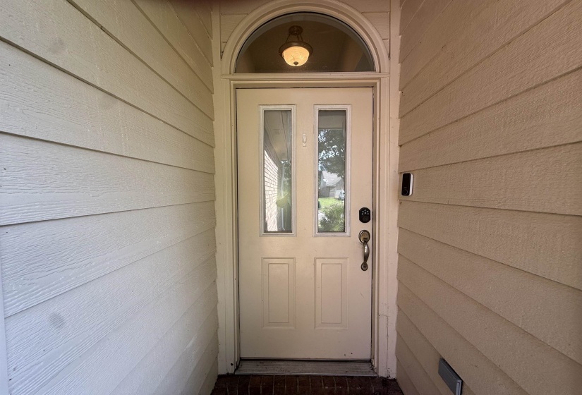 Entry door with two vertical glass panels and an arched transom window