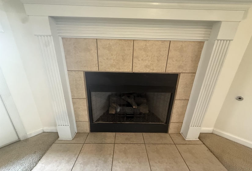 Fireplace featuring a tiled surround, decorative wood mantel with fluted columns, and a tile hearth