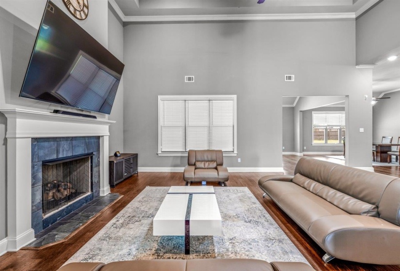 Spacious living area featuring a fireplace with blue-toned tile surround and a white mantel