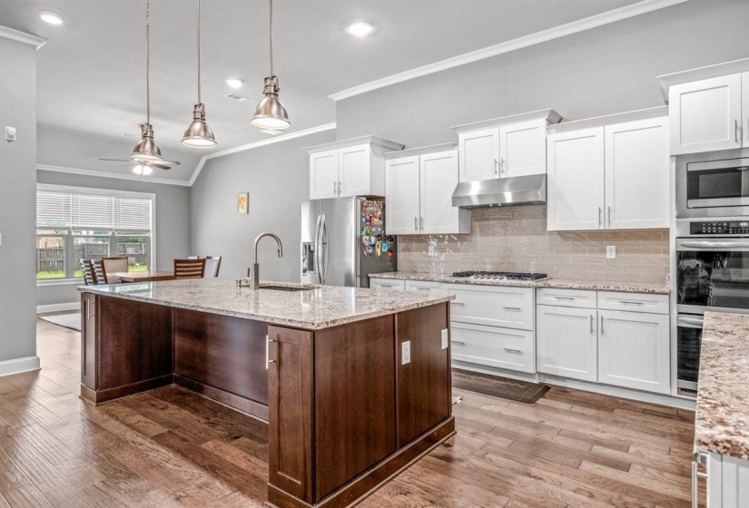 Kitchen featuring a large central island with a built-in sink and pendant lighting