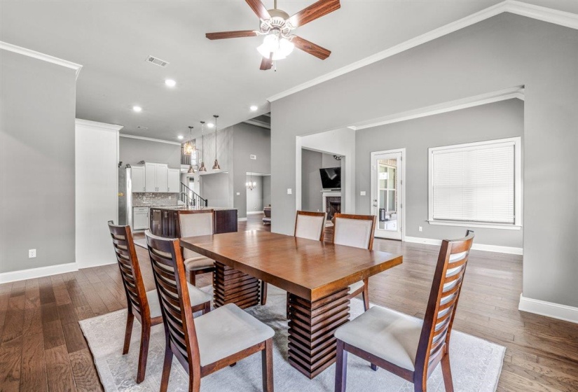 Dining area featuring wood-finish flooring, a ceiling fan, and white crown molding