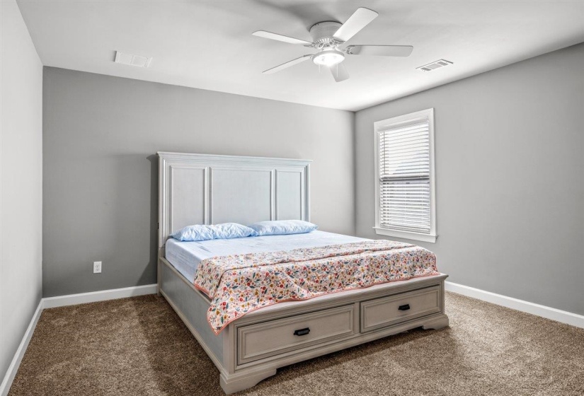 Carpeted room with light gray walls, a ceiling fan with integrated lighting, and a single window featuring white blinds and trim