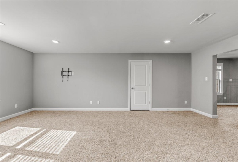 Spacious room featuring neutral carpeting and light gray walls