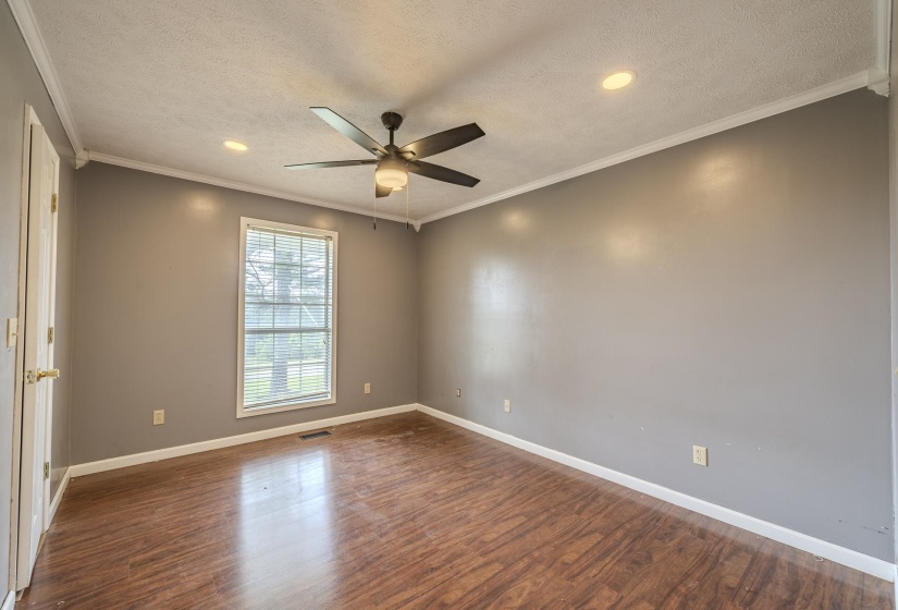 Spacious interior featuring wood-finish flooring, neutral gray walls, and white trim