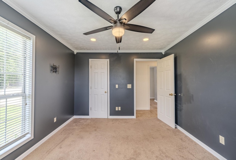 Interior room featuring a ceiling fan with integrated lighting, recessed lighting, crown molding, and neutral carpet flooring
