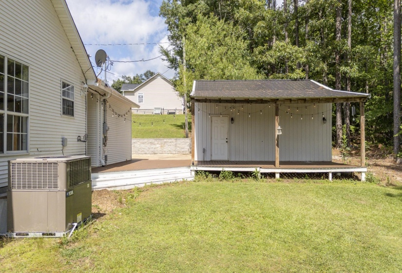 Freestanding outbuilding with a covered porch and white siding