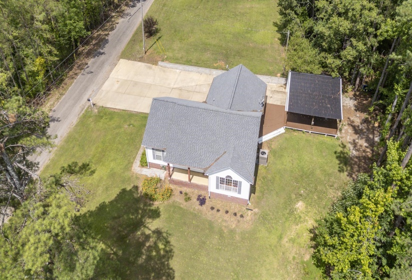 Single-story residence featuring a gray shingle roof, white siding, and a covered front porch with brick accents
