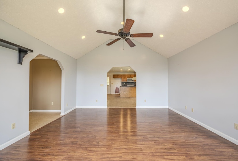 Expansive room featuring a vaulted ceiling with recessed lighting and a ceiling fan