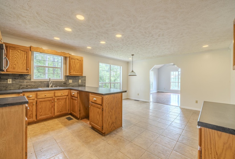 Kitchen featuring wood cabinetry, stone-look countertops, and a tile backsplash